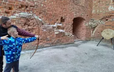 chłopiec strzelający z łuku do tarczy