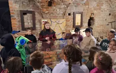 dzieci słuchają historii zamku krzyżackiego