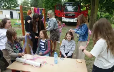 dzieci przy stoisku z pleceniem warkoczy