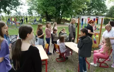 dzieci przy stoisku z pleceniem warkoczy