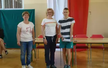 uczeń z nagrodą obok nauczyciel i pani Dyrektor