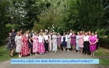 Pracownicy szkoły oraz Rada Rodzic&oacute;w na tle zieleni