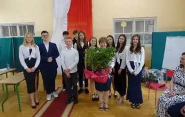 wsp&oacute;lne zdjęcie Pani Dyrektor z absolwentami z przekazanym rododendronem