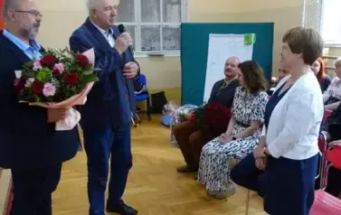 Radni wręczający Pani Dyrektor bukiet kwiat&oacute;w