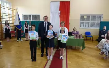 uczniowie z dyplomami Czytelnika Roku wraz z Panią Dyrektor i Panem Burmistrzem