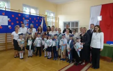 pierwszaki po pasowaniu na ucznia wraz z rodzicami, Panią Dyrektor i Panem Burmistrzem