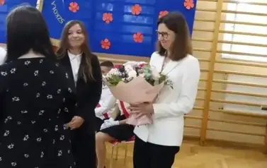 uczniowie wręczają kwiaty pani Dyrektor