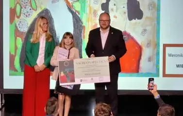 dziewczynka otrzymująca nagrodę z rąk Prezydenta Miasta