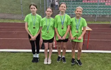 dziewczynki prezentujące medale zdobyte w zawodach sportowych