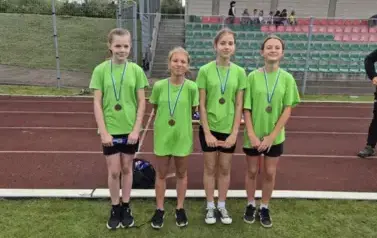 dziewczynki prezentujące medale zdobyte w zawodach sportowych