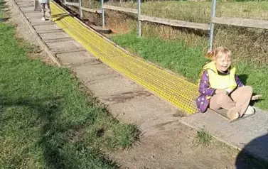 dziewczynka zjeżdżająca na sankach po torze