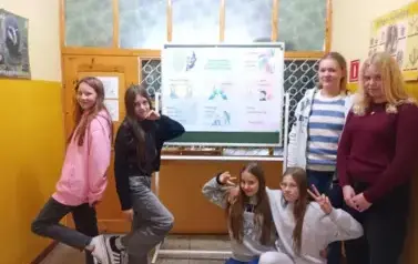 dziewczyny na szkolnym korytarzu , w tle plakat o tematyce przeciwdziałania przemocy i budowania relacji