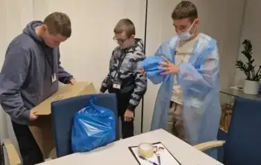 uczniowie pakujący materiąły do przeprowadzenia operacji
