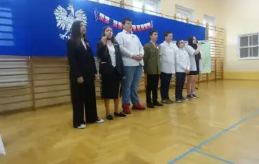 dziewczęta i chłopcy z klasy VIII odśpiewujący pieśni patriotyczne