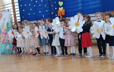 dzieci z oddziału przedszkolnego z papierowymi kwiatkami
