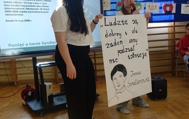 uczniowie klasy &oacute;smej prezentujący sw&oacute;j plakat o Irenie Sendlerowej