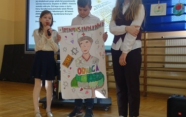 uczniowie z klasy czwartek prezentujący sw&oacute;j plakat o Irenie Sendlerowej