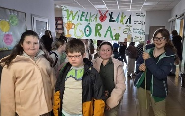 uczniowie z banerem, kibicujący uczestnikom zawod&oacute;w sportowych