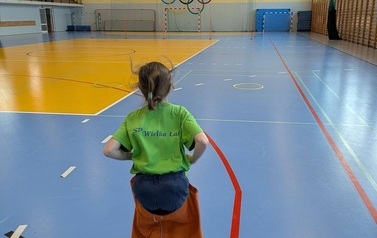 dziewczynka skacząca w worku na zawodach sportowych