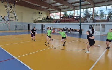 dziewczęta grające w koszyk&oacute;wkę na hali sportowej