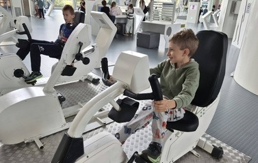 Dw&oacute;jka chłopc&oacute;w korzystających ze stacjonarnych rower&oacute;w