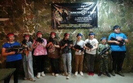 uczniowie prezentujący sprzęt przed rozgrywką paintballa