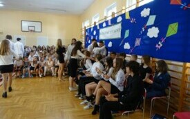 uczniowei klasy si&oacute;dmej wręczający upominki absolwentom szkoły