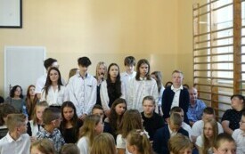 uczniowie klasy si&oacute;dmej składający życzenia dla absolwent&oacute;w szkoły