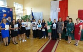 dzieci wraz z rodzicami po odbiorze świadectw z wyr&oacute;żnieniem