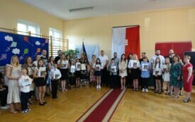 dzieci wraz z rodzicami po odbiorze świadectw z wyr&oacute;żnieniem