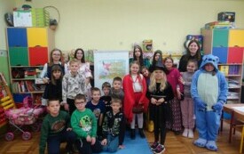 Dzieci z klasy II pozują na tle napisu "Dzień ostaci z bajek"