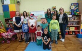 Dzieci z klasy I pozują na tle napisu "Dzień ostaci z bajek"