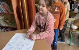 dzieci stawiające pieczątki na plakacie