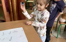 dzieci stawiające pieczątki na plakacie