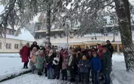 wsp&oacute;lne zdjęcie grupy uczestnik&oacute;w wycieczki przed ośrodkiem wypoczynkowym