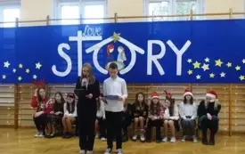 dziewczyna i chłopiec witający gości i przedstawiający program świąteczny 