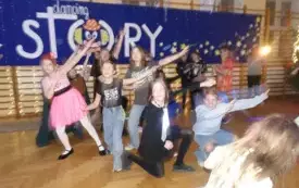 dzieci tańczące na sali na tle napisu "dancing story"