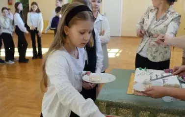 dzieci częstujący się tortem przygotowanym z okazji nadania imienia szkole