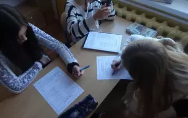 Uczniowie klasy 8 pracujący nad testem wiedzy o patronie Szkoły