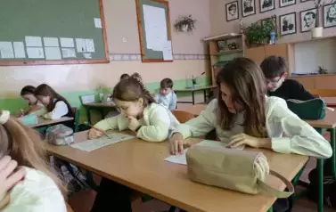 Uczniowie klasy 4 pracujący nad testem wiedzy o patronie Szkoły