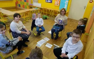 Uczniowie klasy I wraz z wychowawczynią w k&oacute;łku rozmawiają o Patronce Szkoły