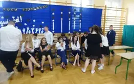 uczniowie klasy VII ręczający upominki absolwentom