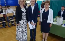 uczeń z wychowawcą i Panią Dyrektor z dyplomem za frekwencje