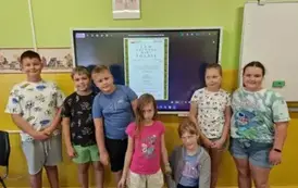 uczniowie na tle tablicy na kt&oacute;rej wyświetla się napis "Jan Kochanowski Poezje"