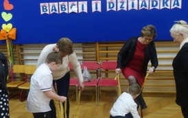 dzieci z dizadkami biorący udział w zabawie z szarfami