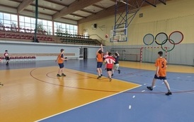chłopcy grający w koszyk&oacute;wkę na hali sportowej