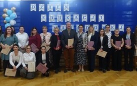 wsp&oacute;lne zdjęcie nauczycieli i pracownik&oacute; szkoły na tle dekoracji z okazji Dnia Edukacji Narodowej