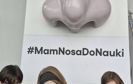 Uczniowie przy interaktywnej ekspozycji w kształcie nosa z hasłem #MamNosaDoNauki podczas zwiedzania wystawy edukacyjnej.
