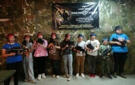 uczniowie prezentujący sprzęt przed rozgrywką paintballa