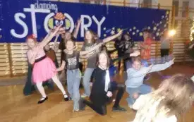 dzieci tańczące na sali na tle napisu "dancing story"